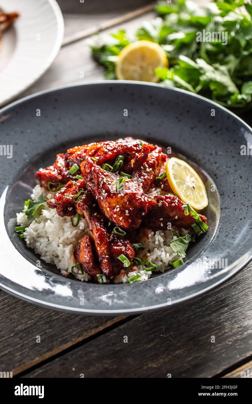 Poulet glacé au miel de style asiatique, feuilles de coriandre, riz et citron. Banque D'Images