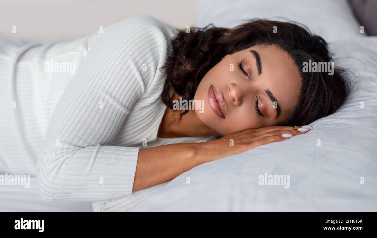Portrait de la jeune femme afro-américaine dormant au lit Banque D'Images