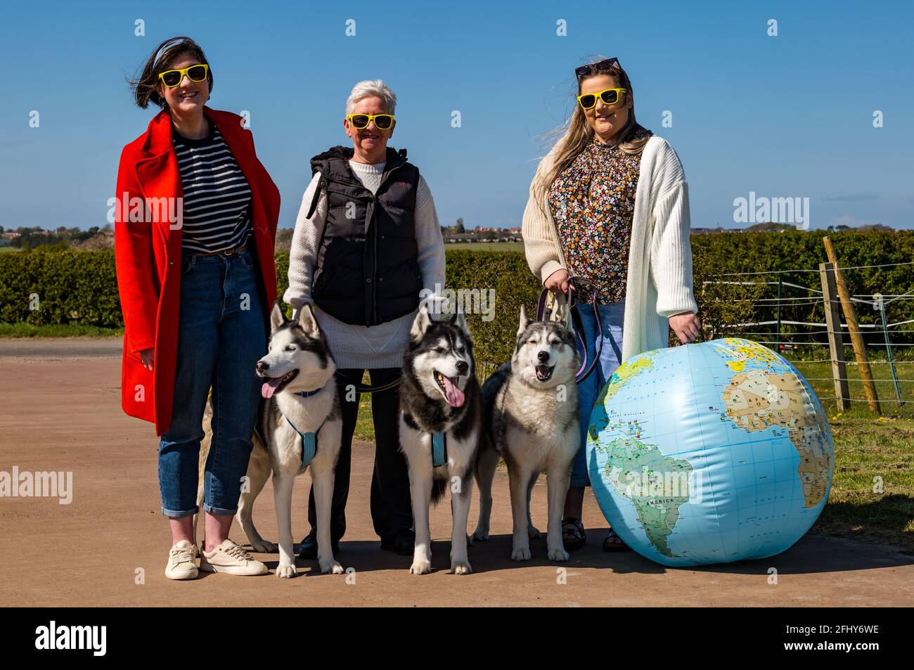 East Lothian, Écosse, Royaume-Uni, 25 avril 2021. Virtual Kilt Walk : les marcheurs de kilt soutenant la charité Muirfield Riding Therapy franchissent une ligne d'arrivée pour célébrer leur participation à leur campagne de collecte de fonds « Round the World ». Photo : l'équipe de BaxterStory qui a parcouru la distance jusqu'à l'Alaska, fêtez avec quelques huskies sibériennes et un monde entier qui a fait exploser Banque D'Images