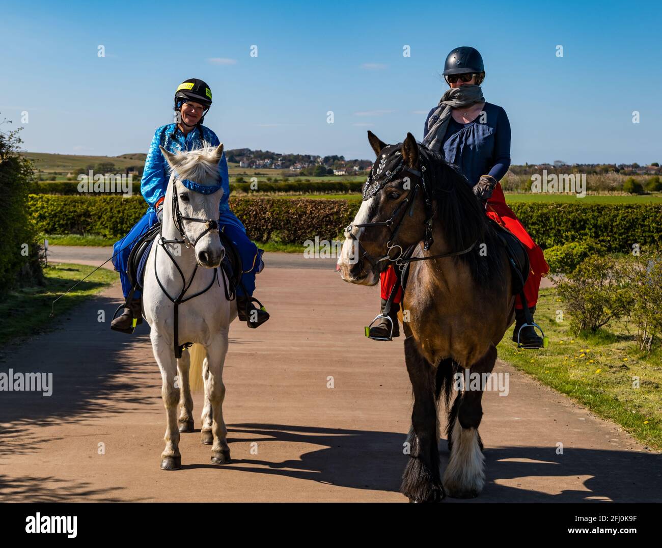 East Lothian, Écosse, Royaume-Uni, 25 avril 2021. Virtual Kilt Walk : les marcheurs de kilt soutenant la charité Muirfield Riding Therapy franchissent une ligne d'arrivée pour célébrer leur participation à leur campagne de collecte de fonds « Round the World ». Photo : Morven McLelland, à cheval sur Johnny & Charity, chevaux de thérapie criblés par Beccy O'Connor. Les femmes et les chevaux sont habillés en costume arabe pour représenter la distance parcourue Banque D'Images