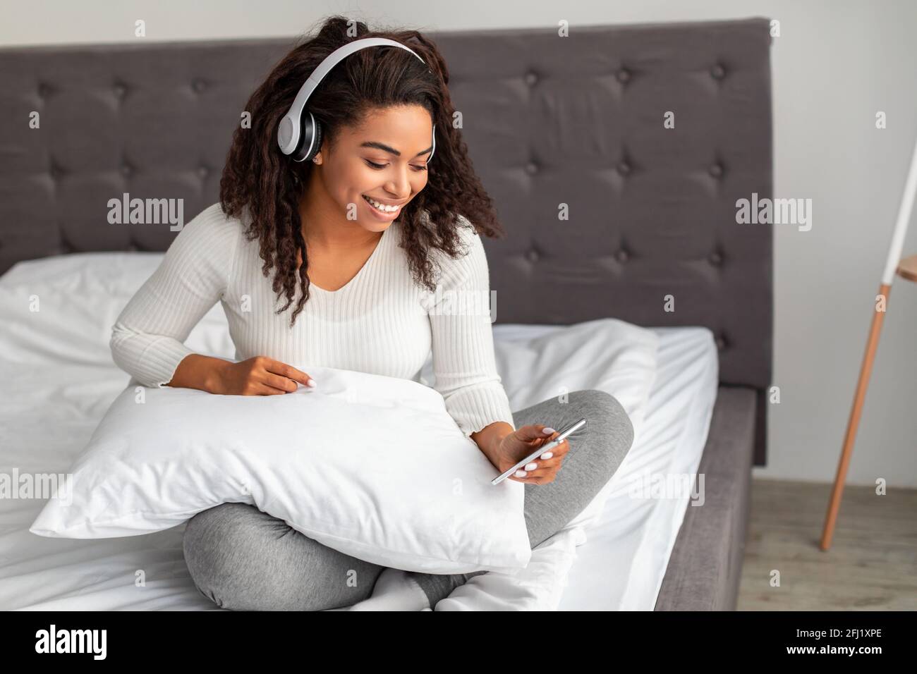 Jeune femme noire satisfaite à l'écoute de musique Banque D'Images