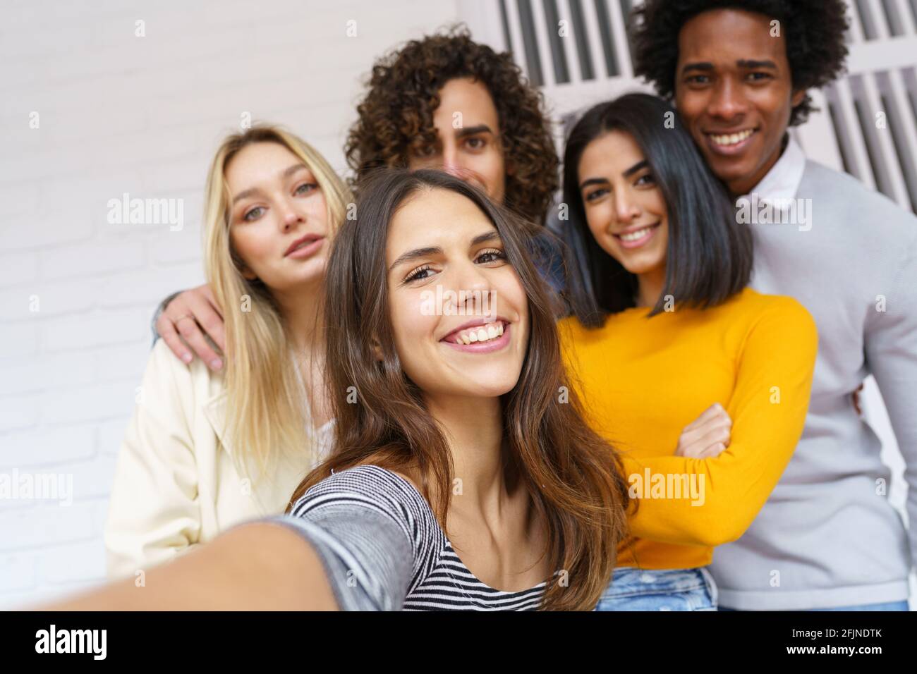 Groupe multi-ethnique d'amis prenant un selfie ensemble tout en s'amusant dehors. Banque D'Images