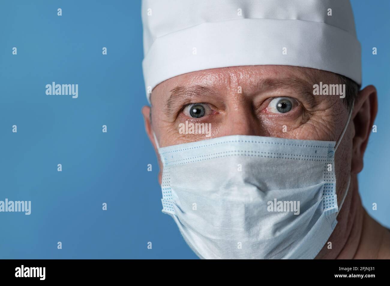 Portrait d'un médecin âgé surpris et effrayé, d'un homme vêque : un chapeau et un masque. Gros plan, regardez la caméra Banque D'Images