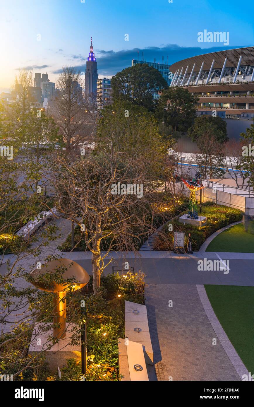 tokyo, japon - février 8 2021 : coucher de soleil à grand angle sur la place olympique sportive japonaise avec le stade national olympique de 2021 et le NTT DoCoMo YOY Banque D'Images