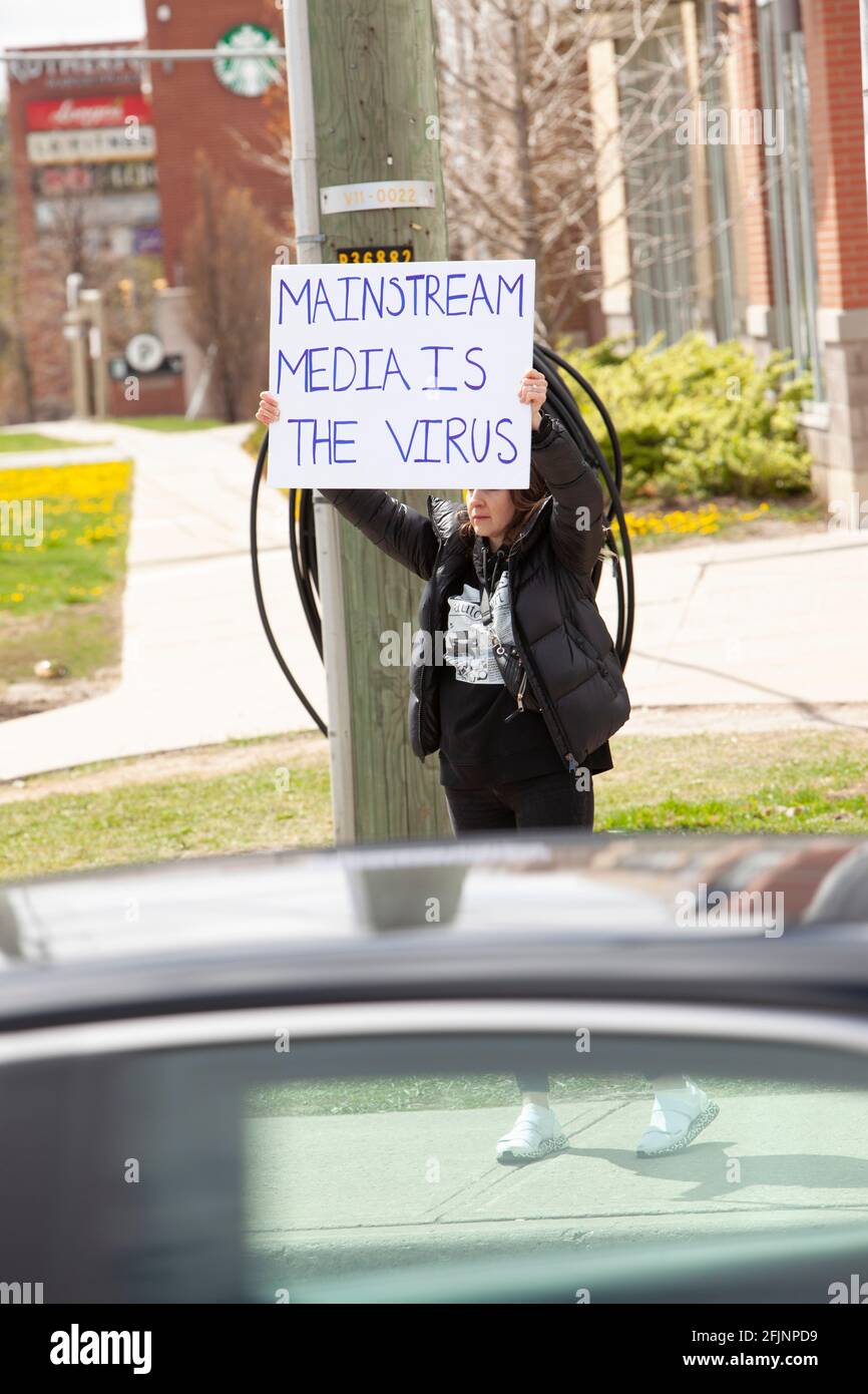 Vaughan, Canada - le 25 avril 2021 : une femme qui détient des médias traditionnels est le signe du virus en signe de protestation contre les mesures de fermeture de la COVID-19 en Ontario Banque D'Images