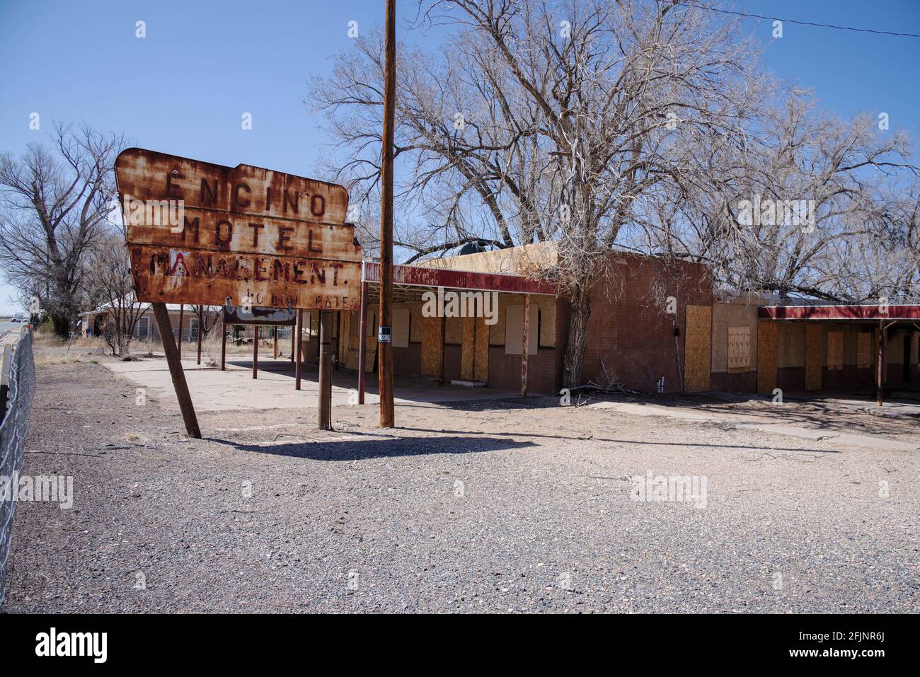 Un grand panneau rouillé et un motel abandonné en bord de route fermé appelé Encino Motel à Encino, Nouveau-Mexique. Banque D'Images