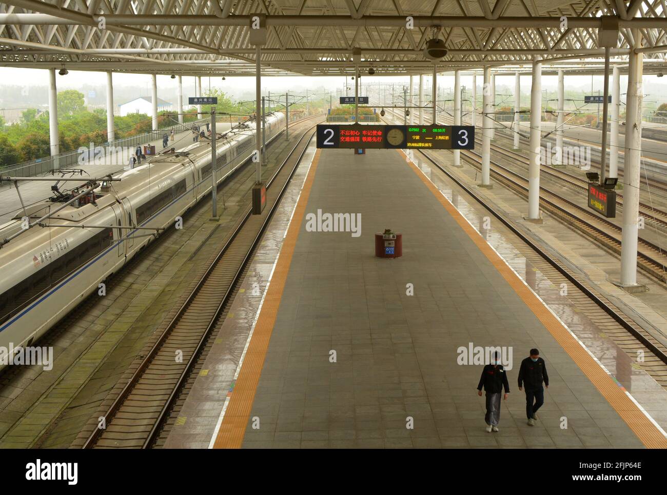 Les gens attendent sur une plate-forme de la gare de Jiaxing sud en Chine pour leur train à arriver. Banque D'Images