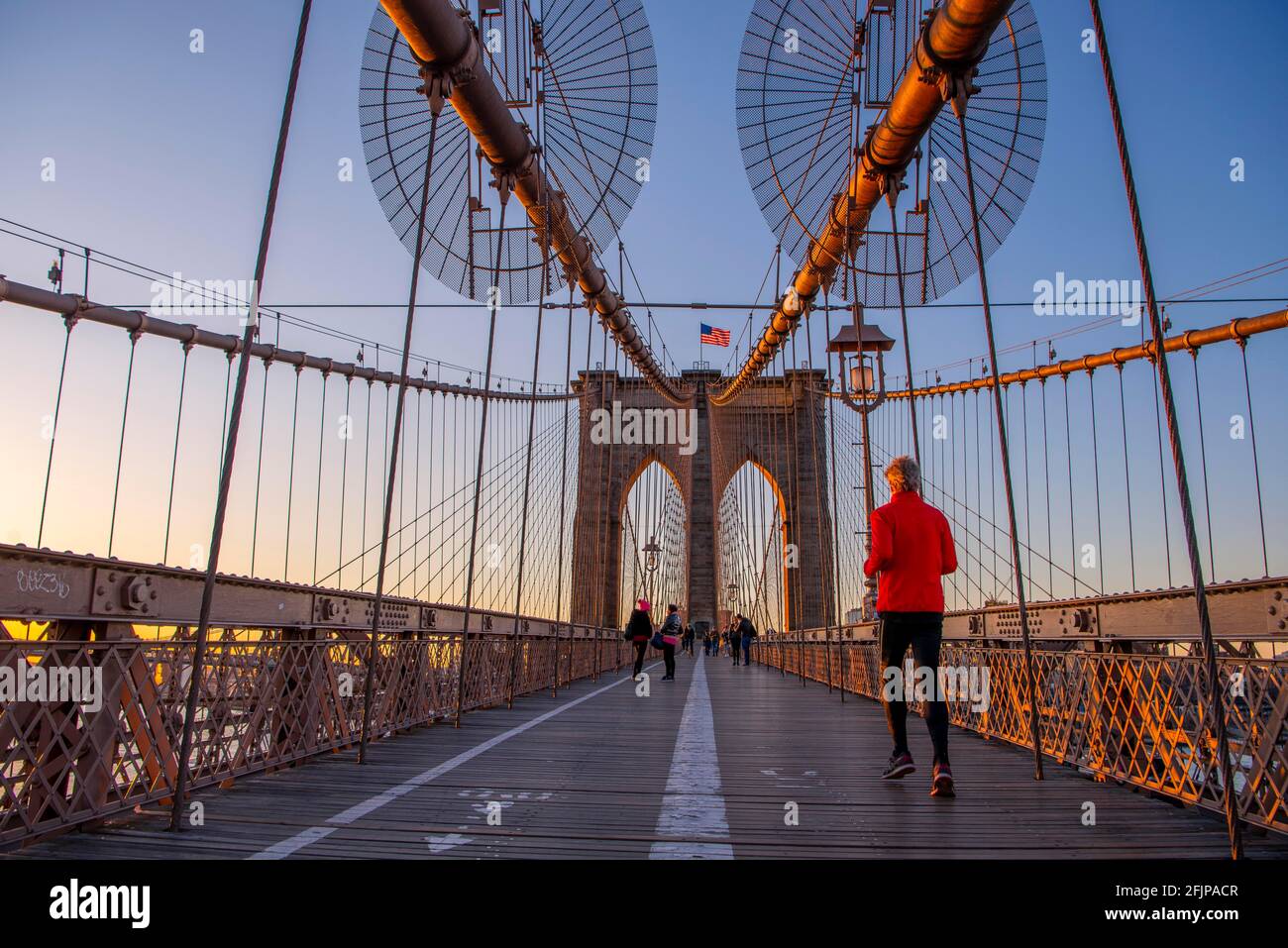 Jogger auf der Brooklyn Bridge BEI Sonnenaufgang, Brooklyn, Manhattan, New York, New York, ÉTATS-UNIS Banque D'Images