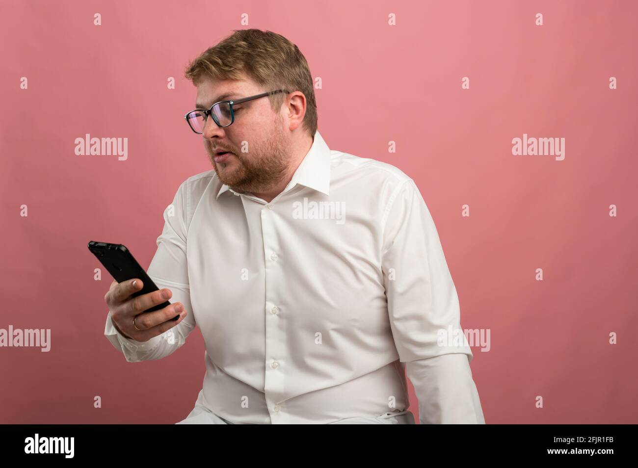 un homme avec des lunettes parle de la communication vidéo et jure, pas heureux, contrarié. Vidéo conférence Banque D'Images