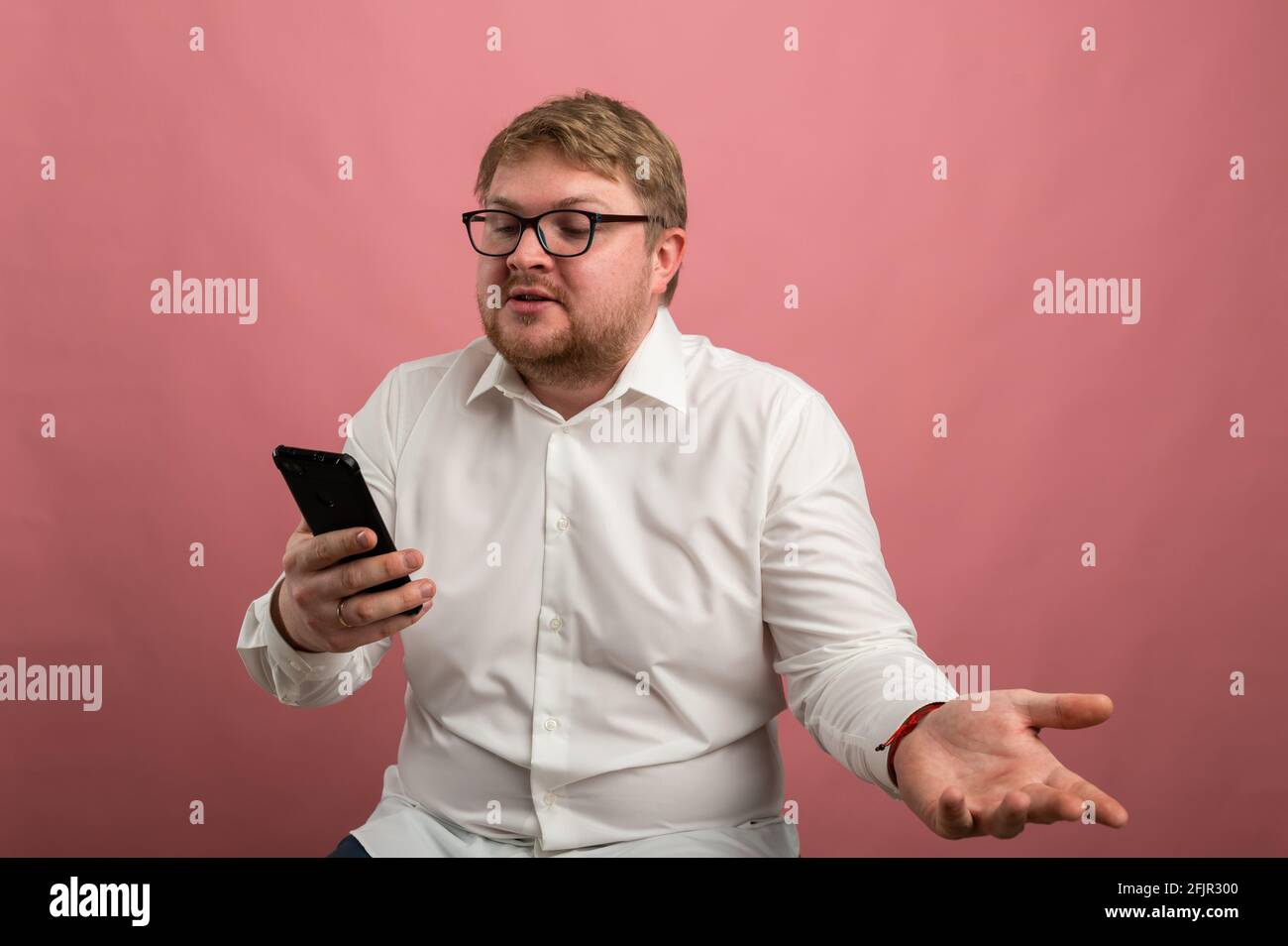 un homme avec des lunettes parle de la communication vidéo et jure, pas heureux, contrarié. Vidéo conférence Banque D'Images