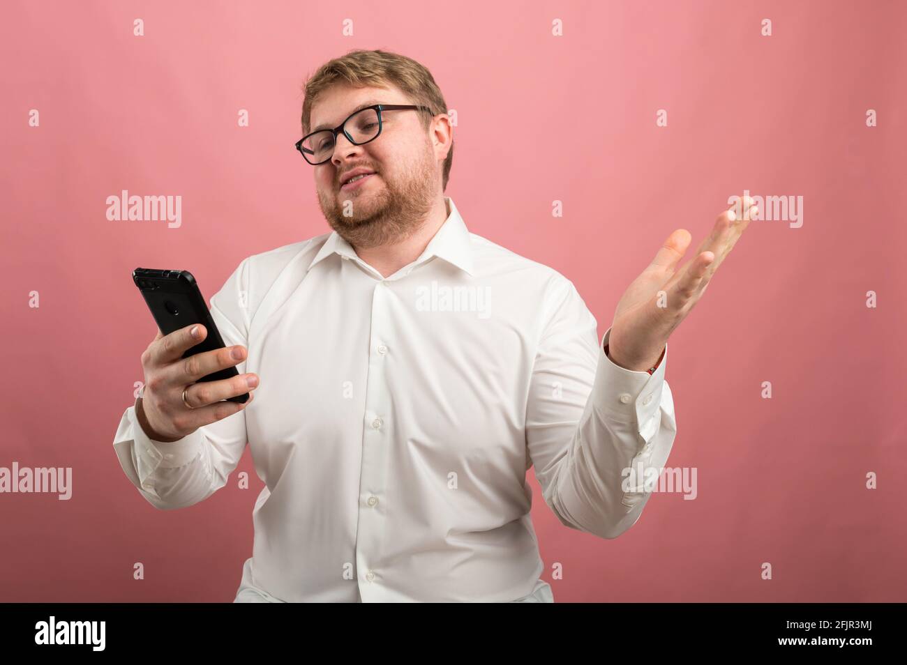 un homme avec des lunettes parle de la communication vidéo et jure, pas heureux, contrarié. Vidéo conférence Banque D'Images