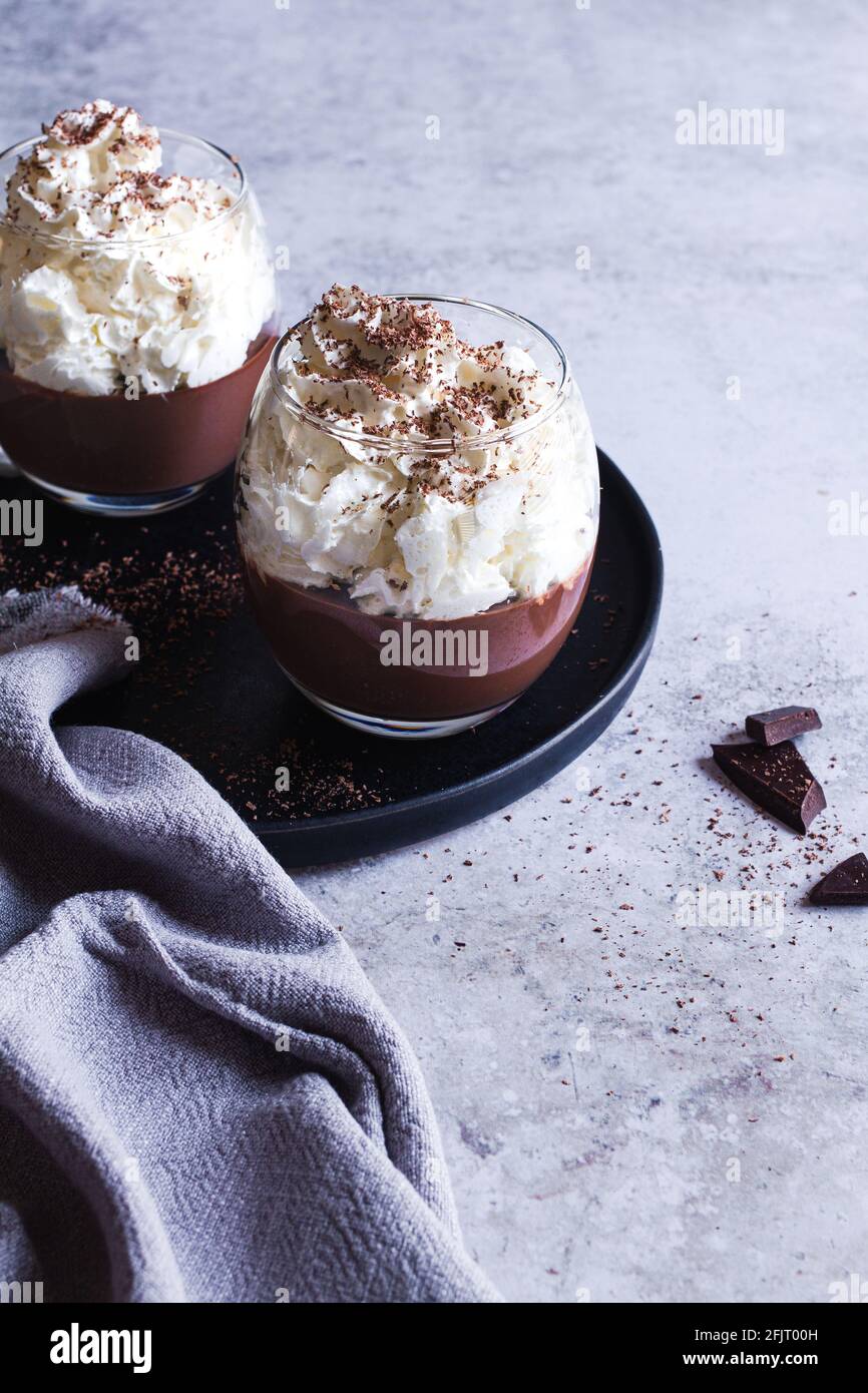 Deux Tasses De Pudding Au Chocolat Liegeois Nappees De Creme Fouettee Et De Chocolat Rape Photo Stock Alamy