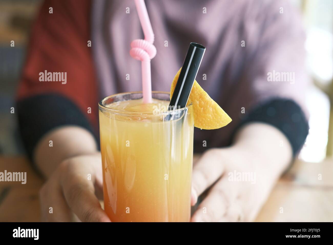les femmes tiennent un verre de jus d'orange Banque D'Images