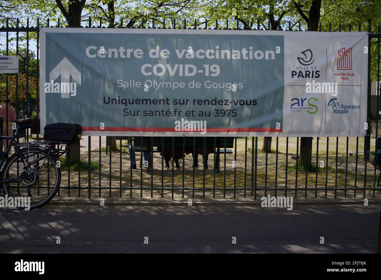 Centre de vaccination Covid-19, Centre de vaccination, salle Olympe de gouges, place de la Roquette, 15 rue Merlin, 75011, Paris, France - avril, 2021 - panneau extérieur avec une femme passant devant Banque D'Images