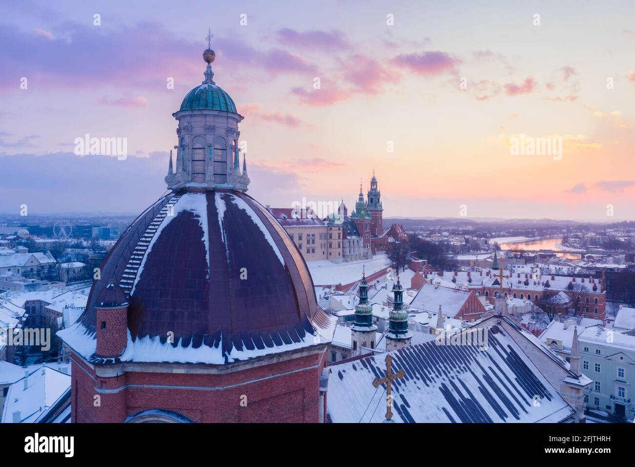 L'hiver à Cracovie, en Pologne, vue aérienne. Dôme de l'église Saint-Pierre-et-Paul, église Saint-André et château royal de Wawel avec la Vistule au coucher du soleil. Banque D'Images