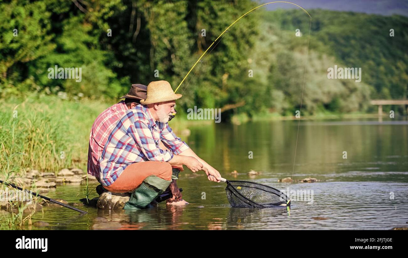 Bonne prise. Hommes barbus pêche. Jour de la famille. Chanceux et qualifiés. Attraper du poisson avec un ami. Les amis pêchent du poisson. Autres pêcheurs. Disques et attachants Banque D'Images