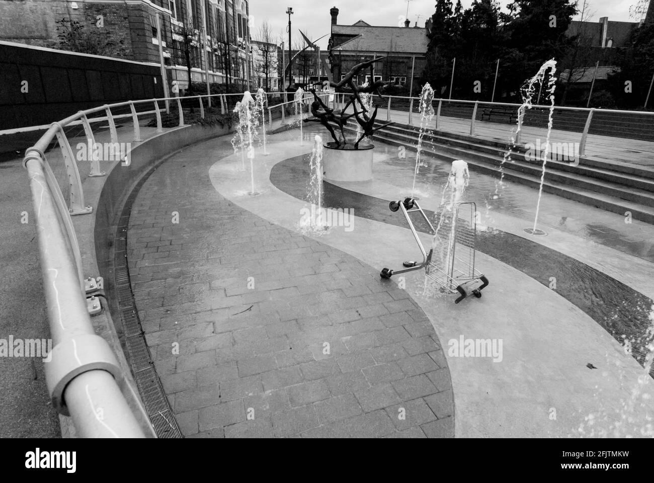 Un chariot à provisions jeté dans la fontaine par les cinq nageurs (une sculpture de David Wynne) devant l'hôtel de ville de Staines, au Royaume-Uni. B&W. Banque D'Images