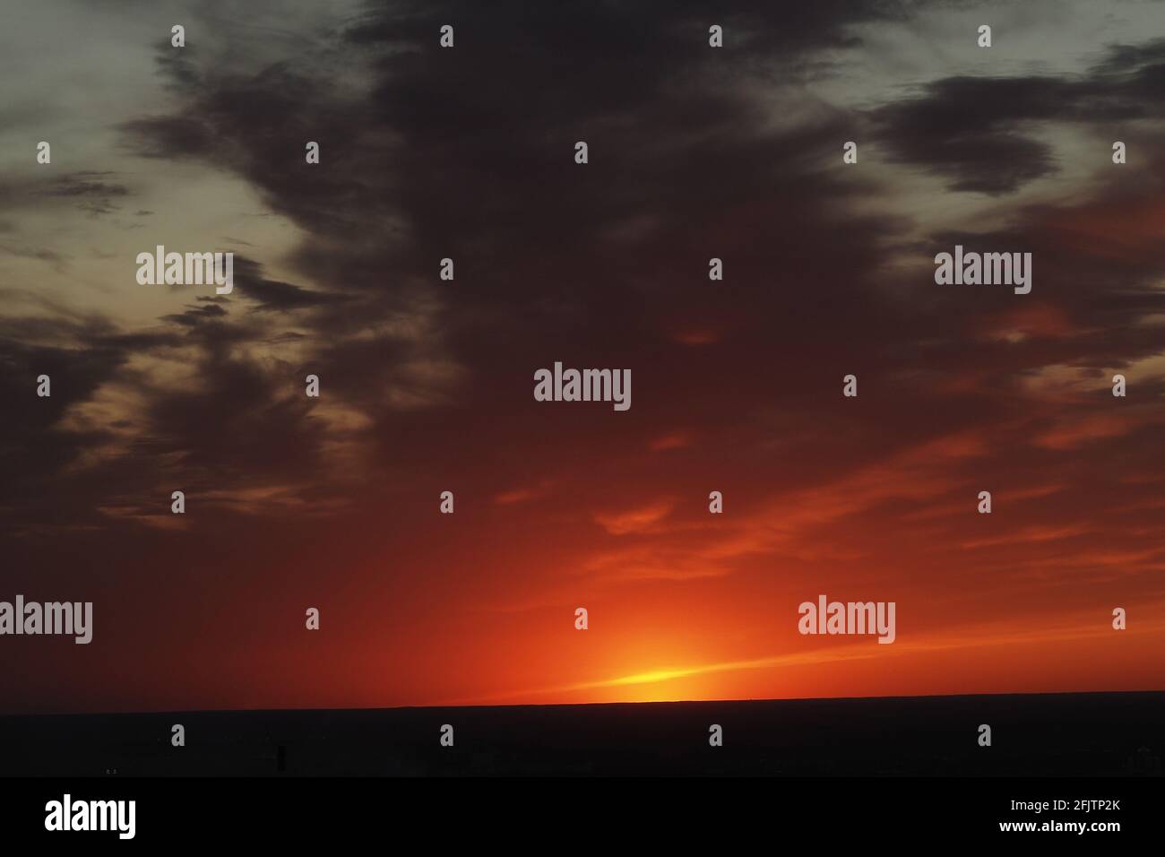 C'est un beau coucher de soleil. Ciel nocturne avec des nuages et le soleil couchant à l'horizon. Banque D'Images