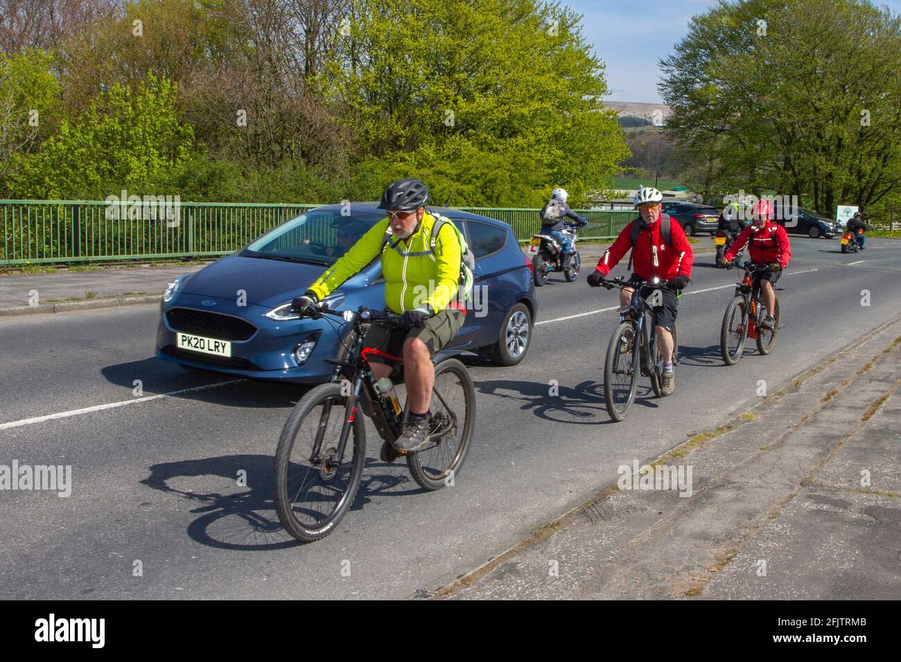 Voiture dépassement cyclistes sur route de campagne; dépassement cycliste, dépassement de véhicule, dépassement de véhicules lents, règle 188 du Code de la route règles pour le dépassement des cyclistes sur route. Banque D'Images