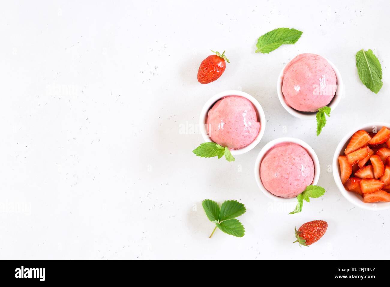 Boule de glace à la fraise dans un bol sur fond de pierre blanche avec espace de texte libre. Vue de dessus, plan d'appartement Banque D'Images