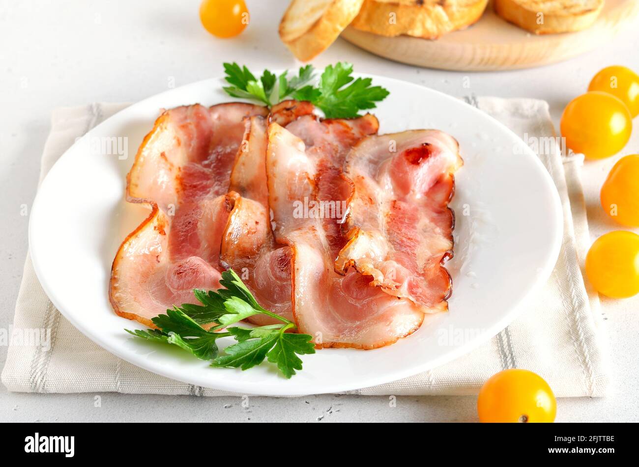 Tranches de bacon frit sur fond de pierre blanche Banque D'Images