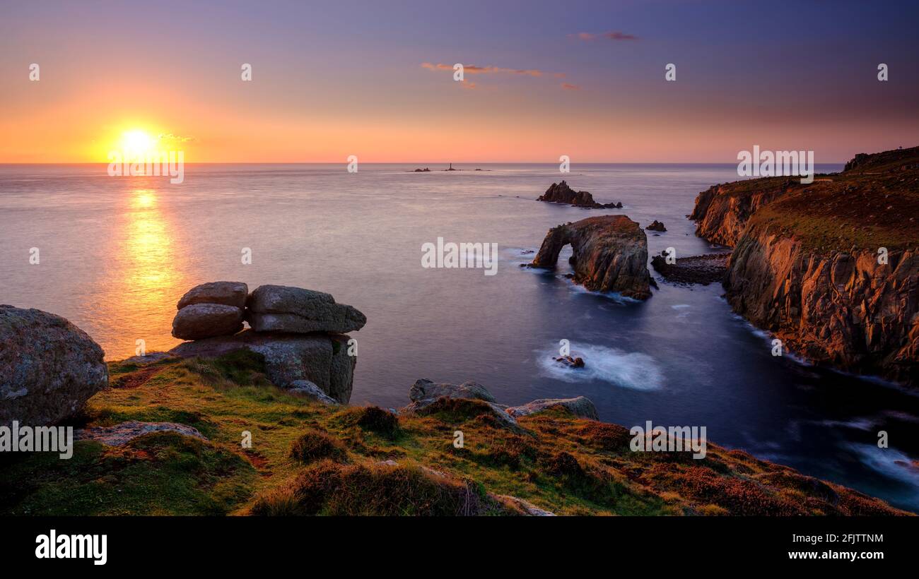 Land's End, Royaume-Uni - 14 octobre 2020 : coucher de soleil d'automne au-dessus de Land's End avec la maison de lumière de Longships, le rocher du Chevalier armé et l'ar naturel d'Enys Dodnan Banque D'Images