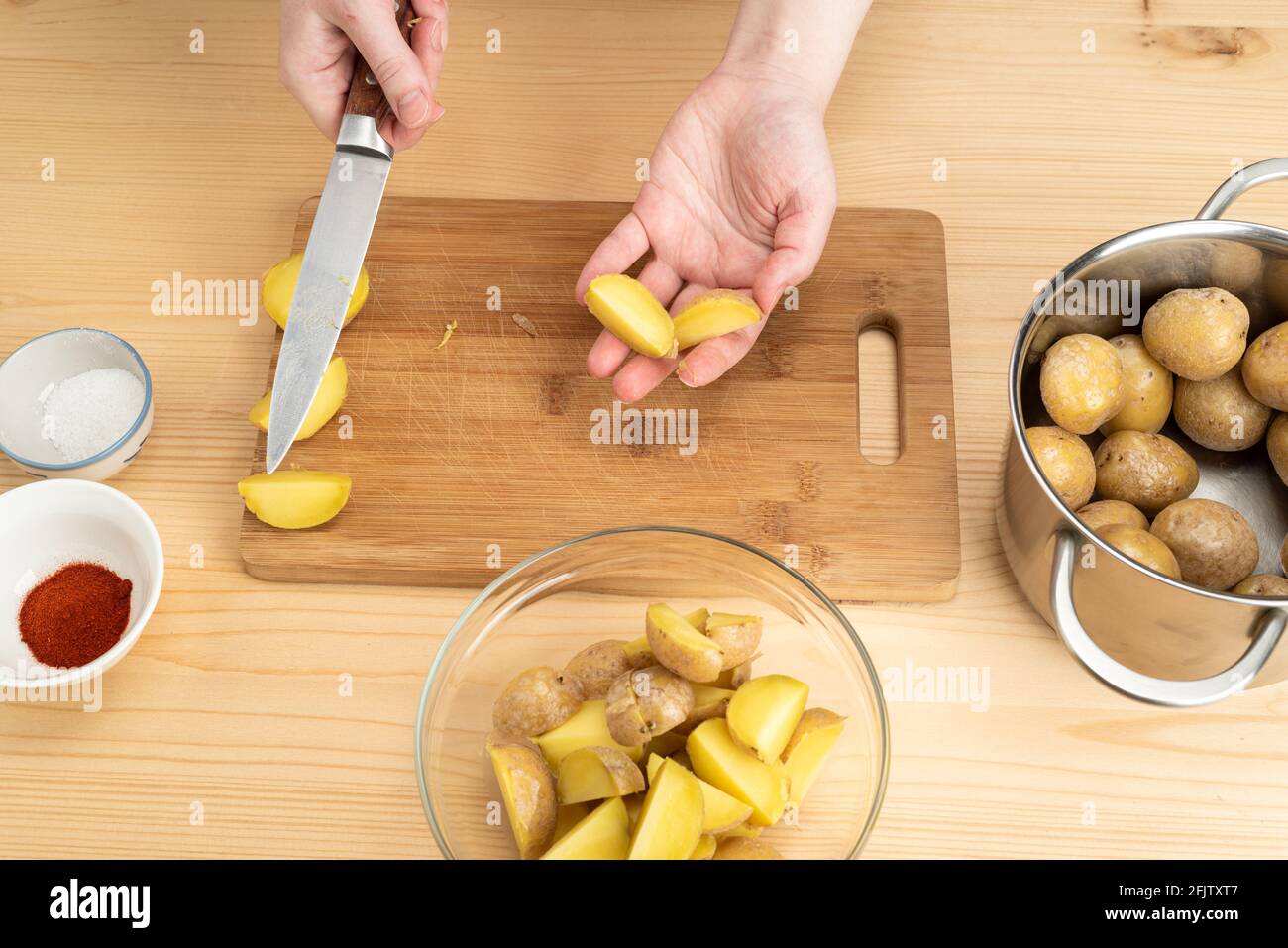 Couper les pommes de terre bouillies sur la paume d'une jeune femme. Une option pour cuisiner des pommes de terre de l'Idaho. Banque D'Images