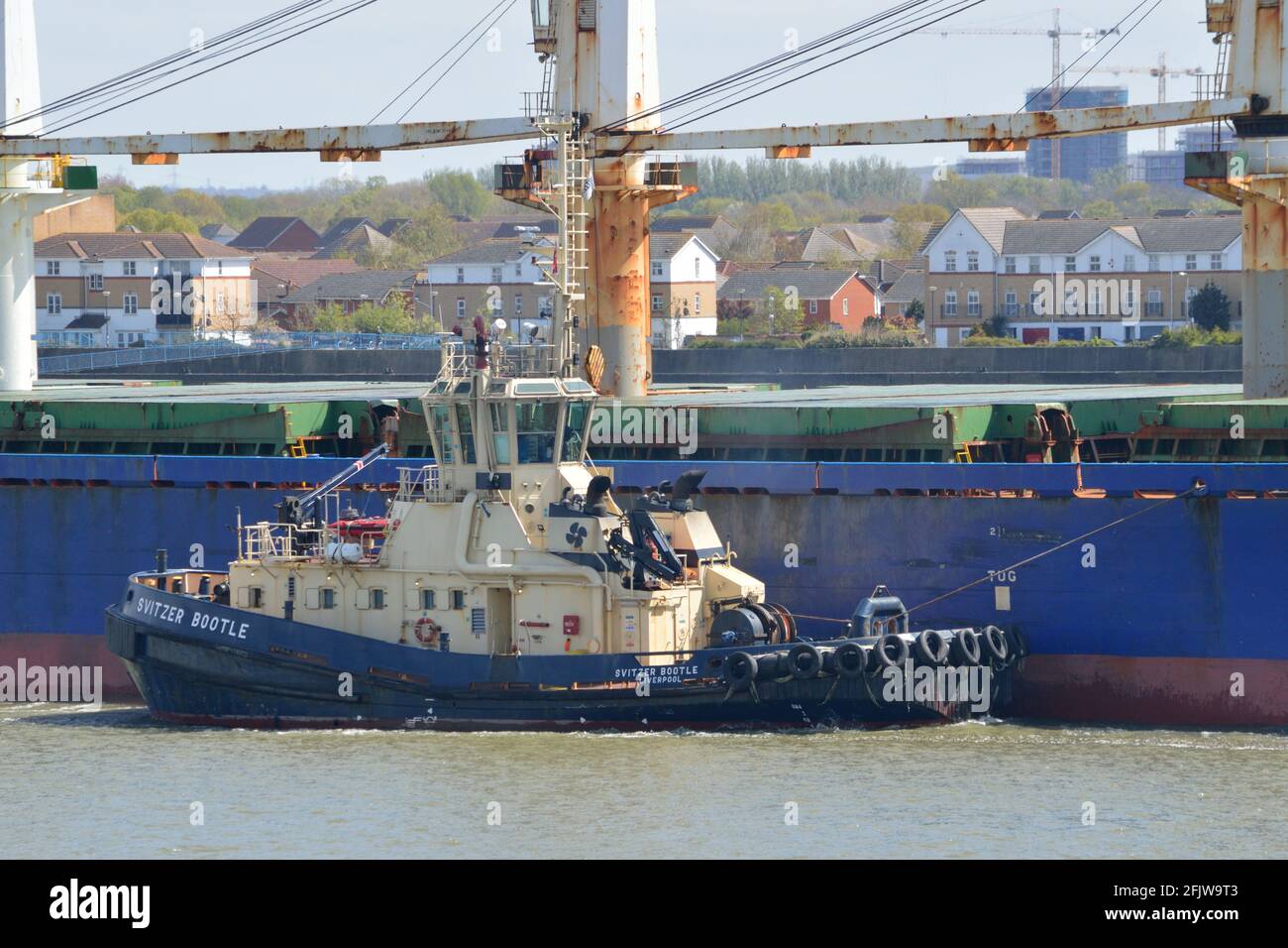 Le remorqueur Svitzer Bootle aide un gros cargo à monter La Tamise à Londres Banque D'Images