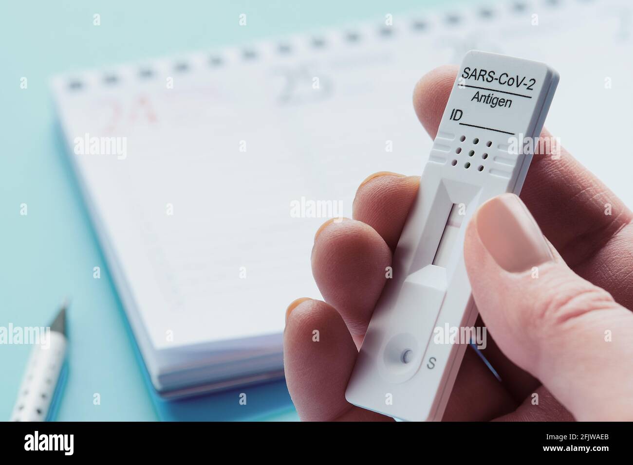 Planificateur de semaine, chnelltest, test rapide de corona en langue allemande. Calendrier du planning hebdomadaire sur table bleue. Concept test-to-Go. Banque D'Images