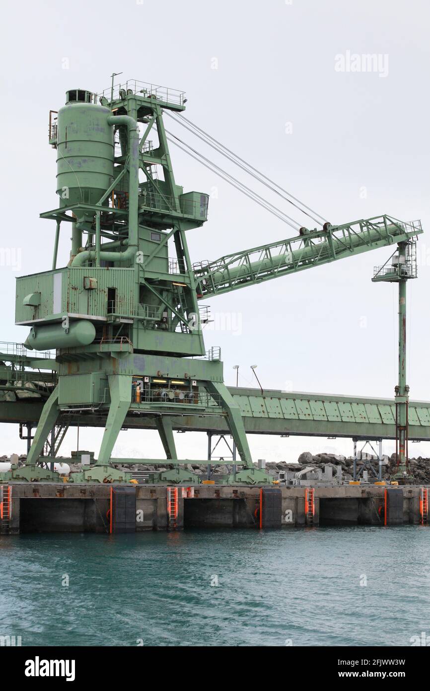 La grue verte est près du transporteur. Équipement d'un port islandais le jour d'hiver Banque D'Images