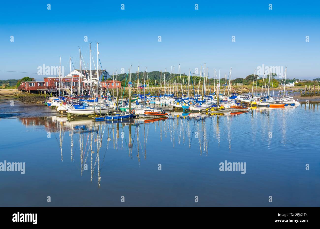 Arun Club de Yacht et Bateaux à voile avec reflets dans l'eau sur la rivière Arun à Littlehampton, West Sussex, Angleterre, Royaume-Uni. Banque D'Images