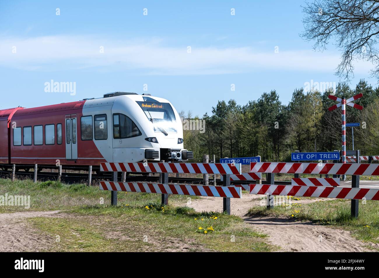 Passage à niveau non surveillé pour cyclistes et piétons, avec train de passage Banque D'Images