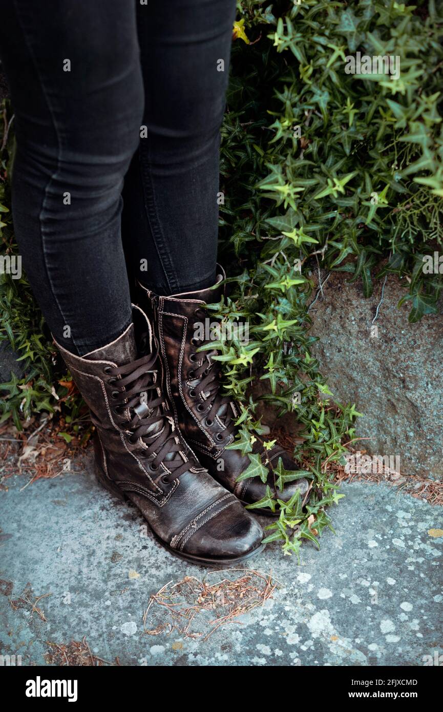 Jambes pour femmes en Jean noir et bottes en cuir noir avec ivy vert Banque D'Images