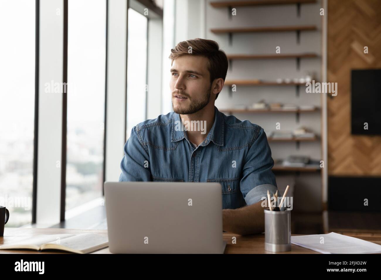 Un homme caucasien pensif travaille sur la pensée d'un ordinateur portable Banque D'Images