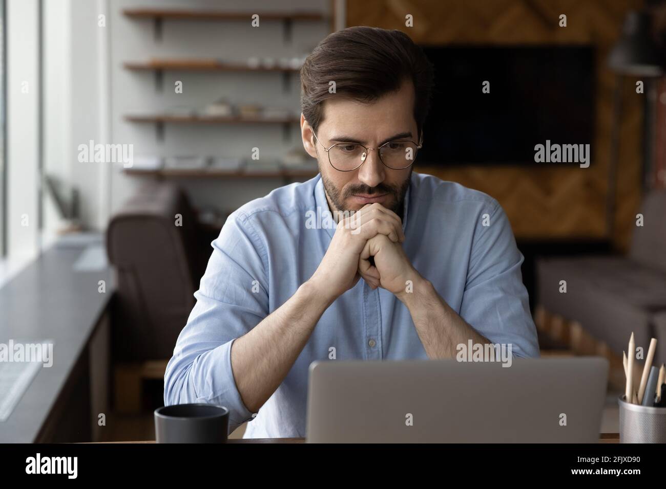Un homme d'affaires pensif travaille sur la prise de décision d'un ordinateur portable Banque D'Images