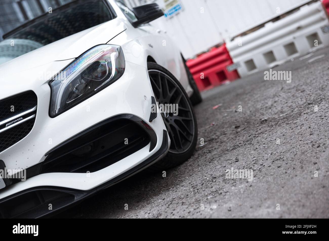 Le phare avant à DEL portant la marque AMG sur UNE Mercedes Benz A45 AMG 2017 Cirrus White avec Aero Pack et roues en alliage noir brillant. Banque D'Images