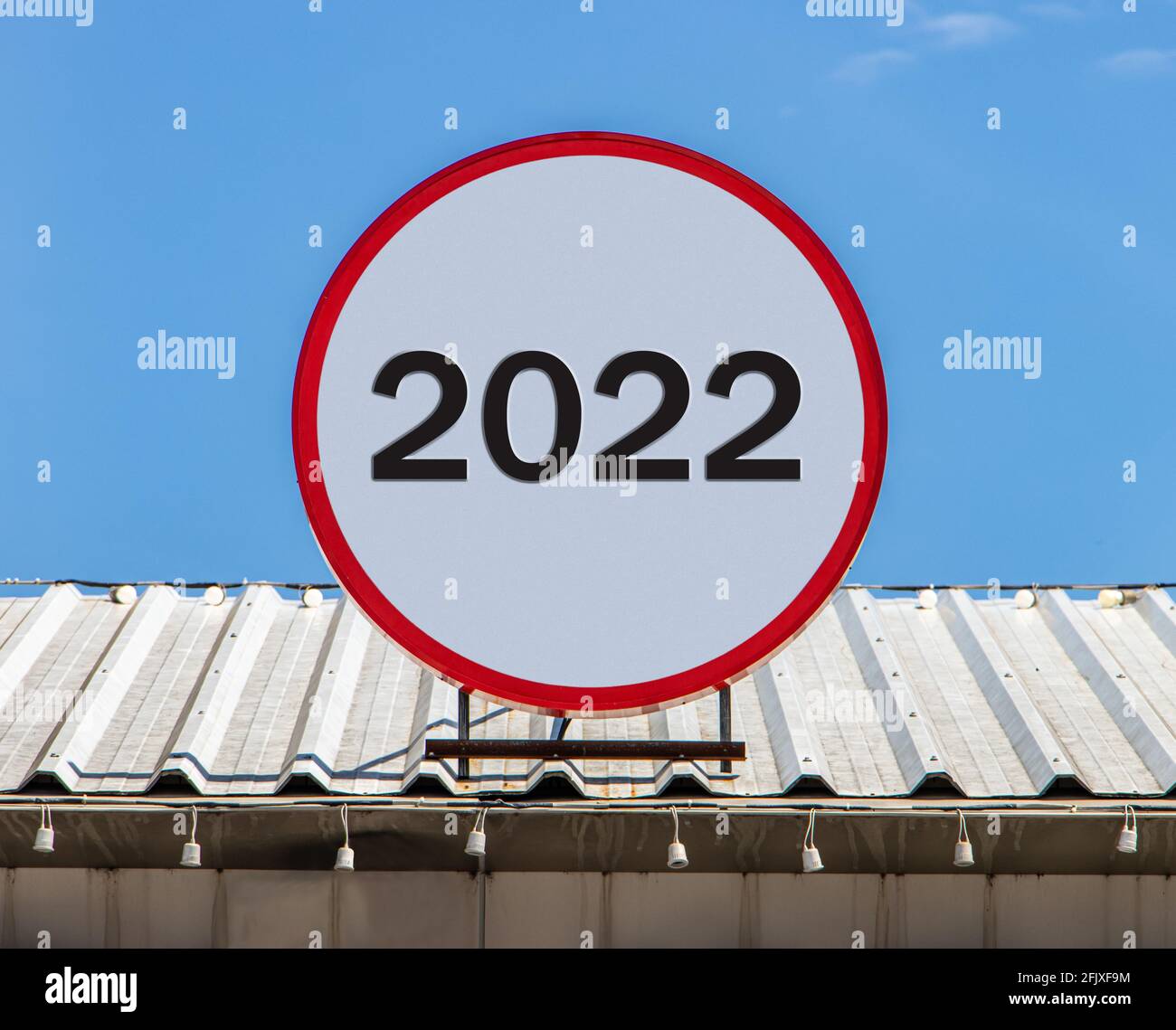Un panneau d'affichage circulaire portant le numéro 2022 est installé sur un toit. Salutation pour le nouvel an 2022. Banque D'Images