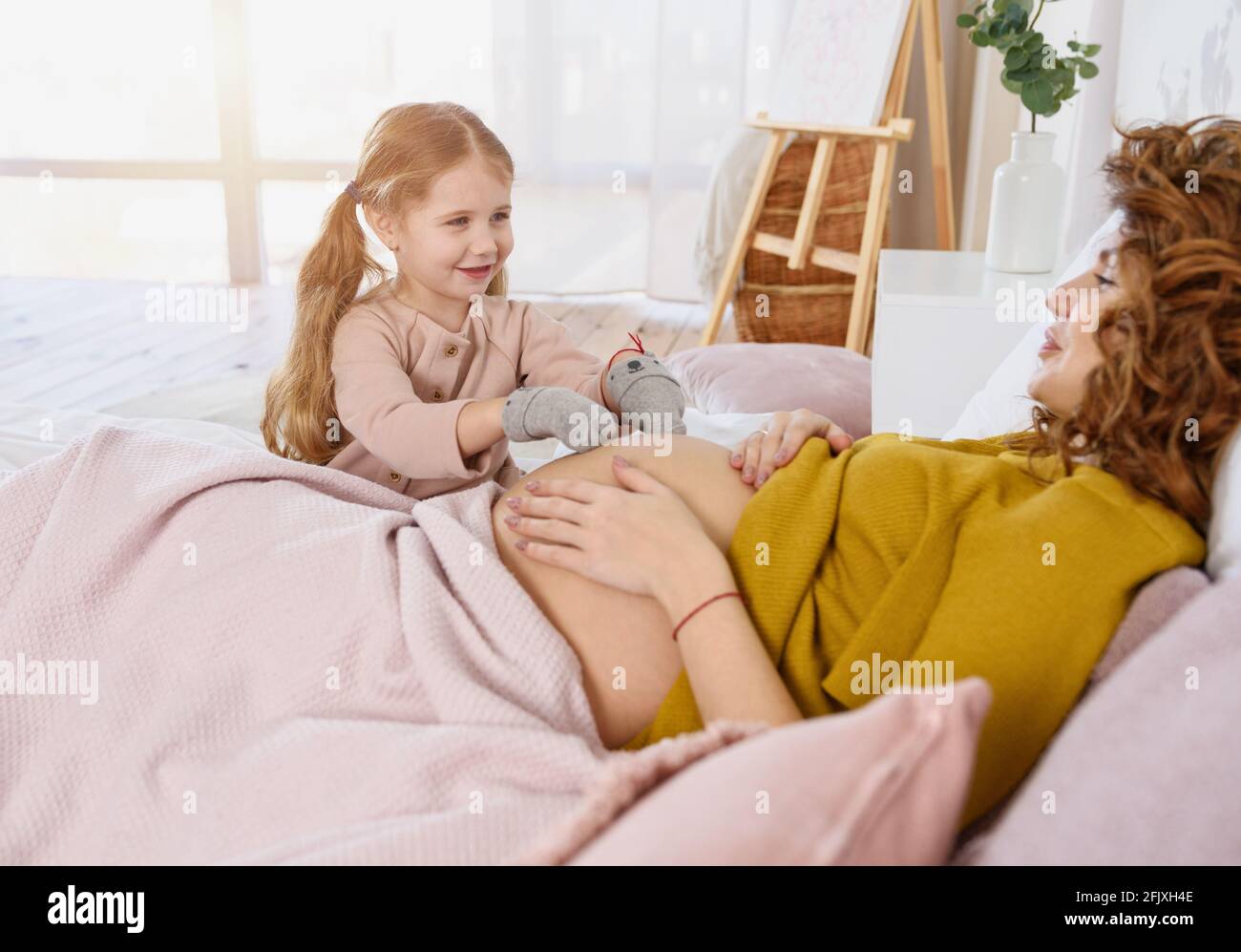 La mère enceinte joue avec sa fille. Concept de famille, de joie et de grossesse Banque D'Images