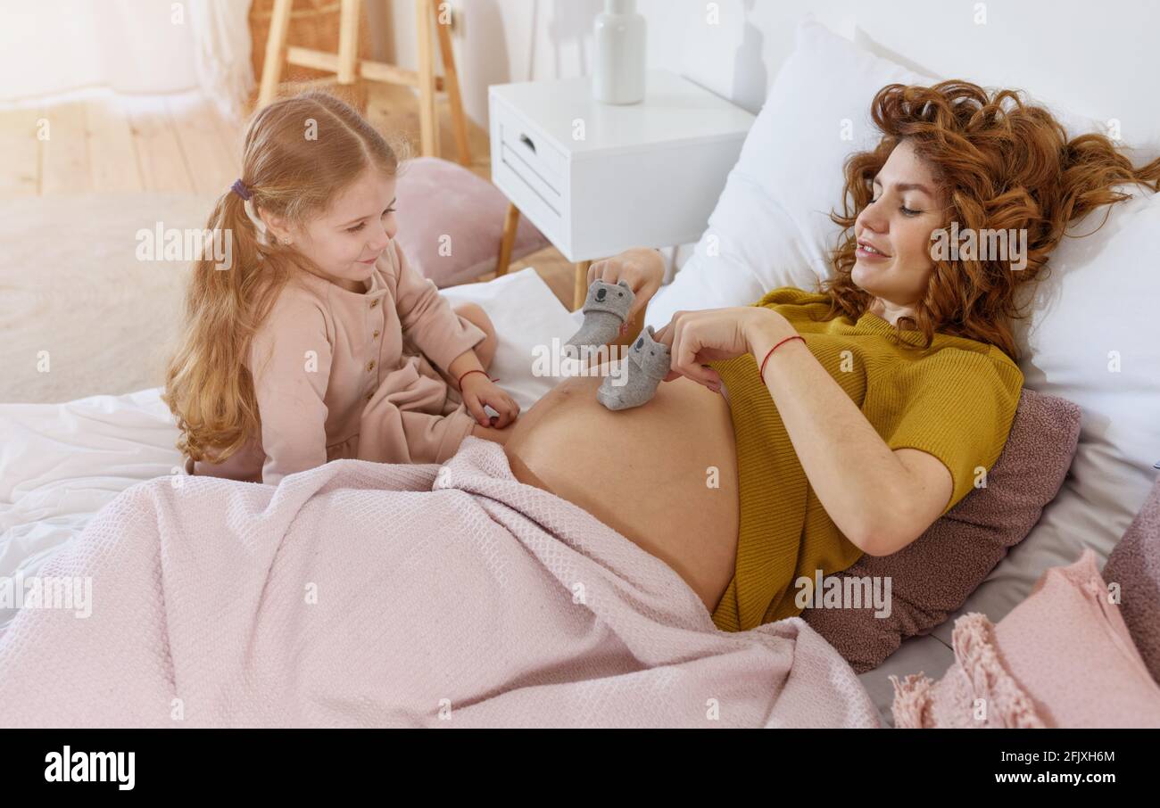 La mère enceinte joue avec sa fille. Concept de famille, de joie et de grossesse Banque D'Images