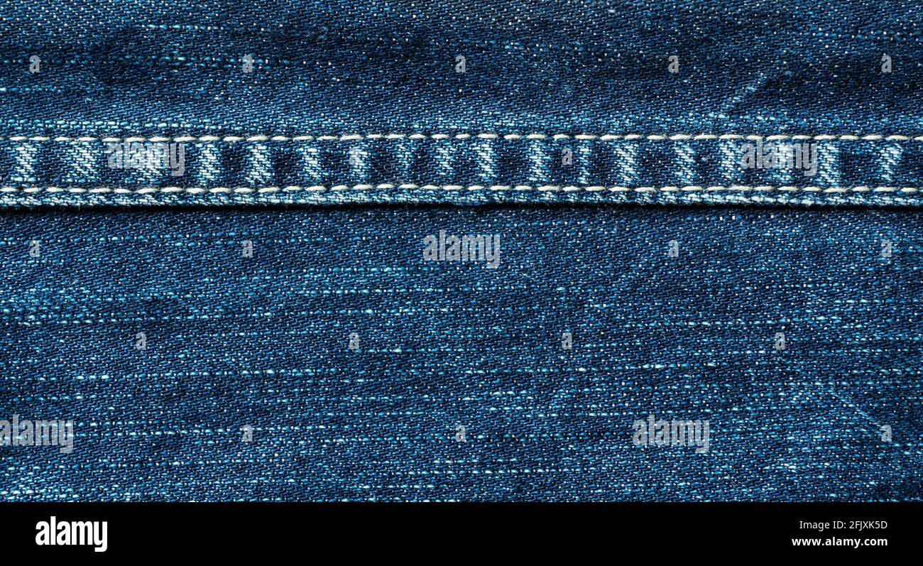 Gros plan des coutures sur un Jean bleu à travers l'écran. Matériau de fond Banque D'Images