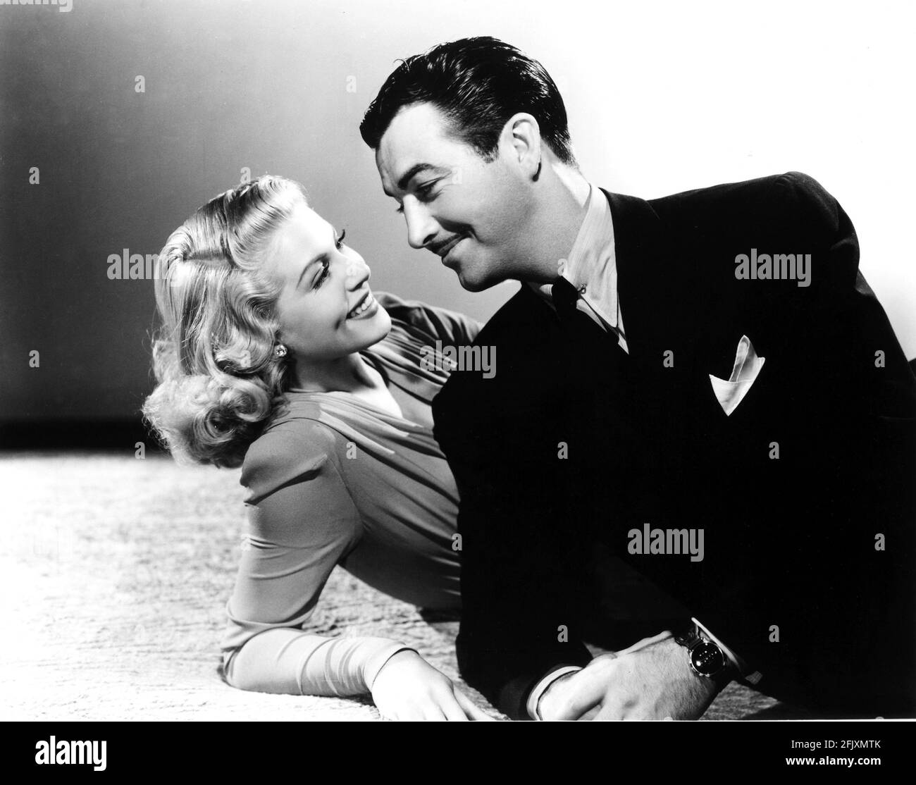 1942 , USA : l'actrice LANA TURNER ( 1920 - 1995 ) avec ROBERT TAYLOR dans JOHNNY EAGER ( Sorvegliato specale ) par MERVYN LEROY , Ppubblicity STILL - CINÉMA - atrice cinematografica - portrait - ritratto - bionda - blondie - capelli biondi - cheveux blonds - profilo - profil - pochette - fazzoletto nel chino - cravate - cravatta - collier - colletto - fermacatta - pin - orecchini - rafino - tascorecchino - pinces - rafino - rafino - tascorecrafino - rafino goutte - goutte - goutte - gioielli - gioiello - bijou - bijoux - bijoux - orologio da polso - nuance - sourire - sorriso - amanti - amoureux - innamorati ---- Archivio GBB Banque D'Images