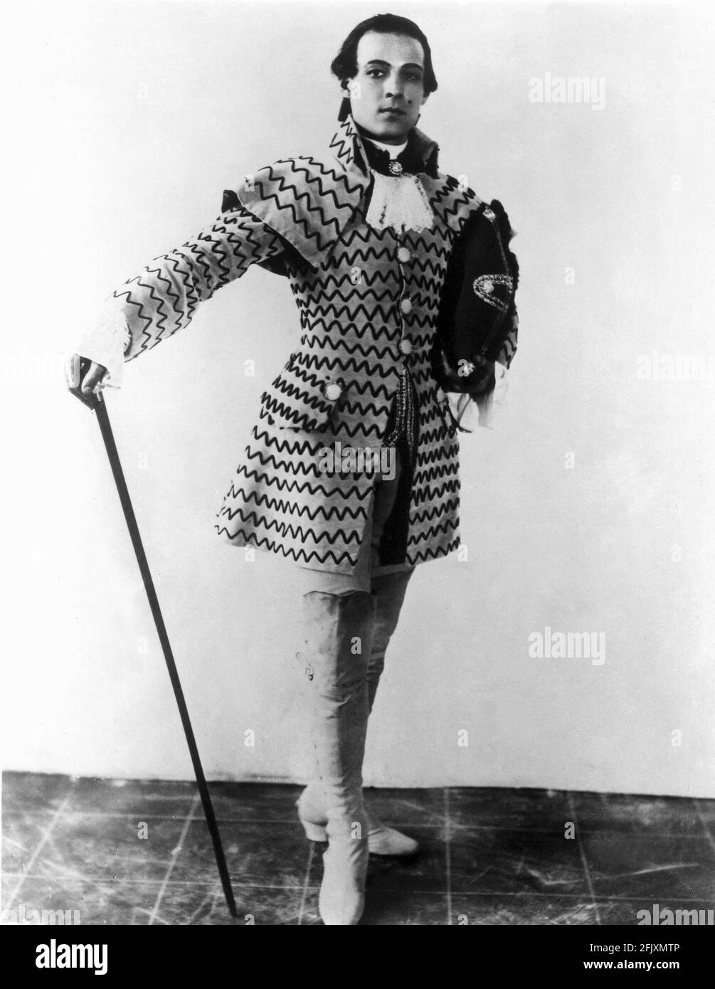 1924 , USA : l'acteur de cinéma sur écran silencieux RUDOLPH VALENTINO ( né Rodolfo Guglielmi , 1895 - 1926 ), test d'écran pour MONITEUR BEAUCAIRE par Sydney Olcott , du roman de Booth Tarkington , Costume de George Barbier - CINÉMA MUTO - RODOLFO VALENTINO - attore camografico - neo - mole - bastone da passeggio - canne - bottes - stivalii - collier - colletto - AMANT LATIN - italoamericano - italo americano - italo-americano - emigrante - italo-américain - portrait - émigrante - Ritratto - parrucca - perruque --- Archivio GBB Banque D'Images