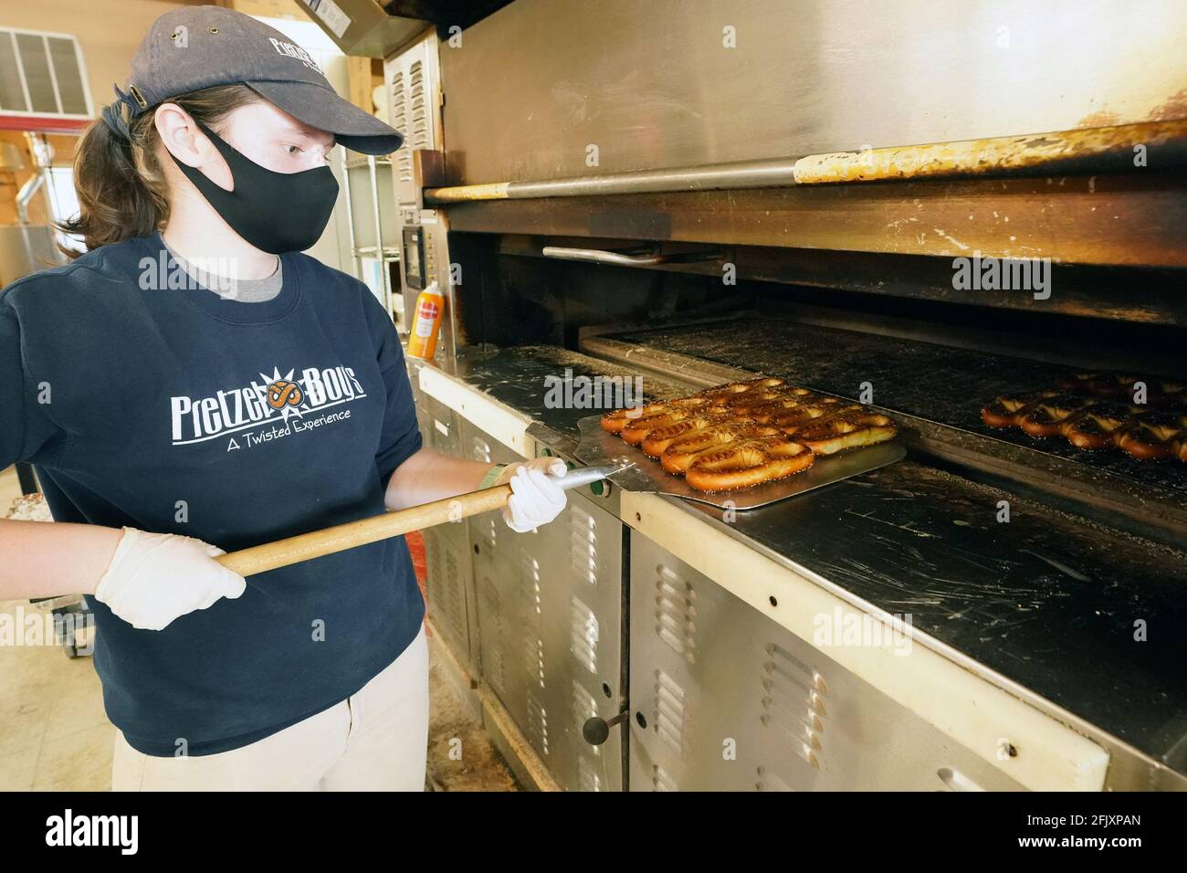 St. Louis, États-Unis. 26 avril 2021. L'ouvrier Kate Albes enlève les bretzels chauds du four à Pretzel Boy's Pretzels le jour national de Pretzel à Saint-Louis, le lundi 26 avril 2021. Photo par Bill Greenblatt/UPI crédit: UPI/Alay Live News Banque D'Images