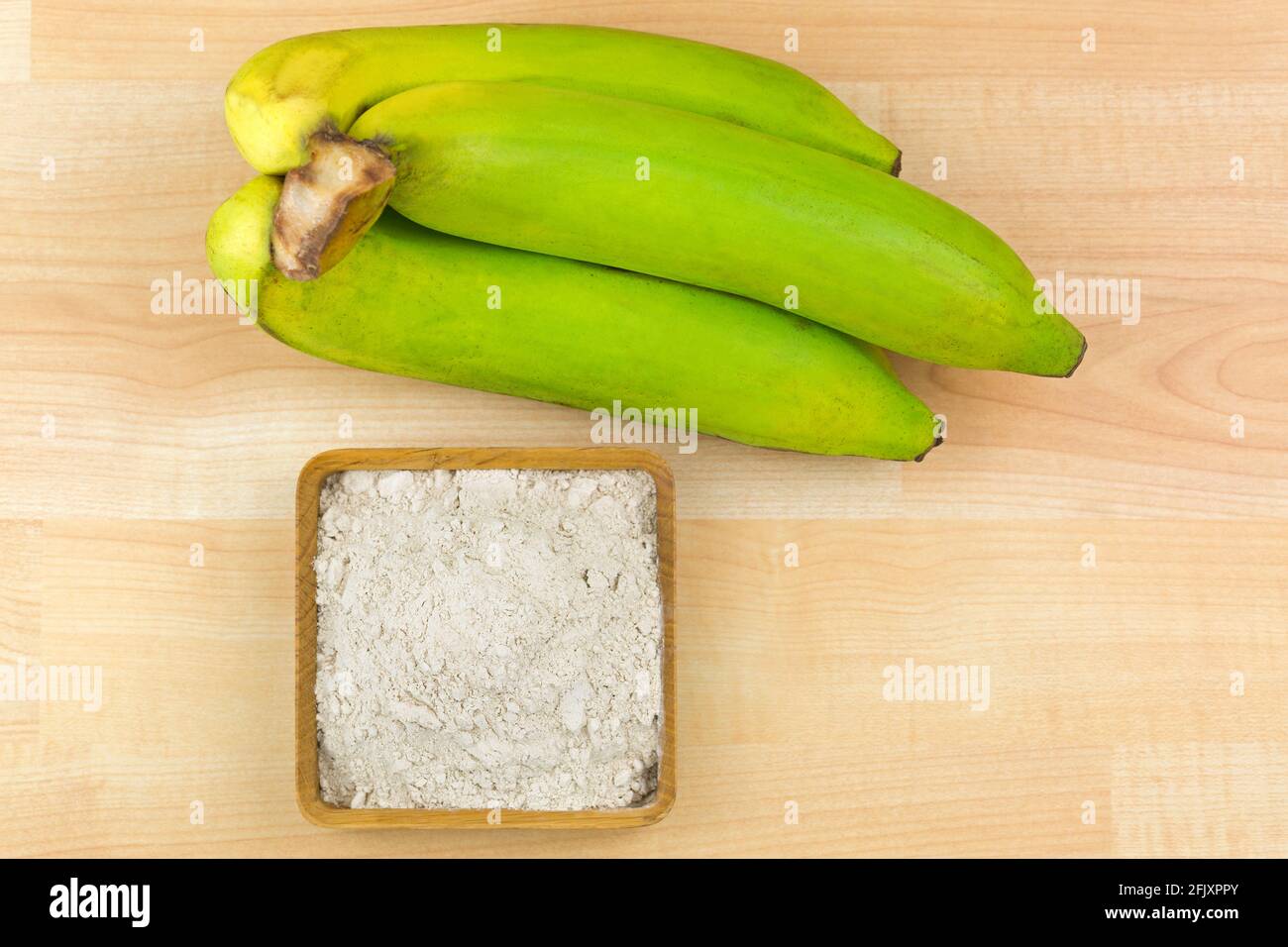 Poudre de banane séchée Synbiotique faite de banane biologique entière du gros Michel, connue sous le nom de Big Mike, vue de dessus sur fond en bois Banque D'Images