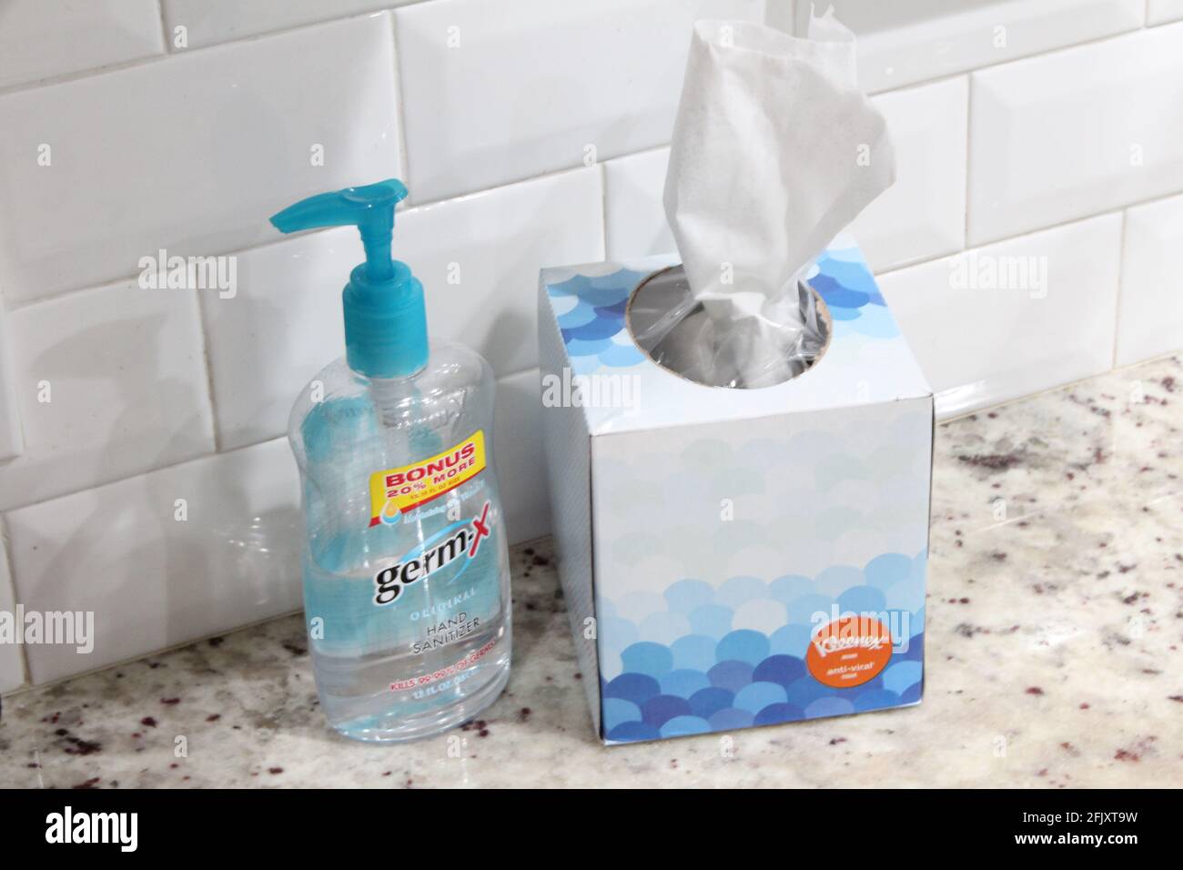 Désinfectant pour les mains Germ-X et boîte pour tissus Kleenex, anti viral, sur une surface en marbre pour tuer les germes dus à la pandémie COVID-19 également connue sous le nom de coronavirus Banque D'Images