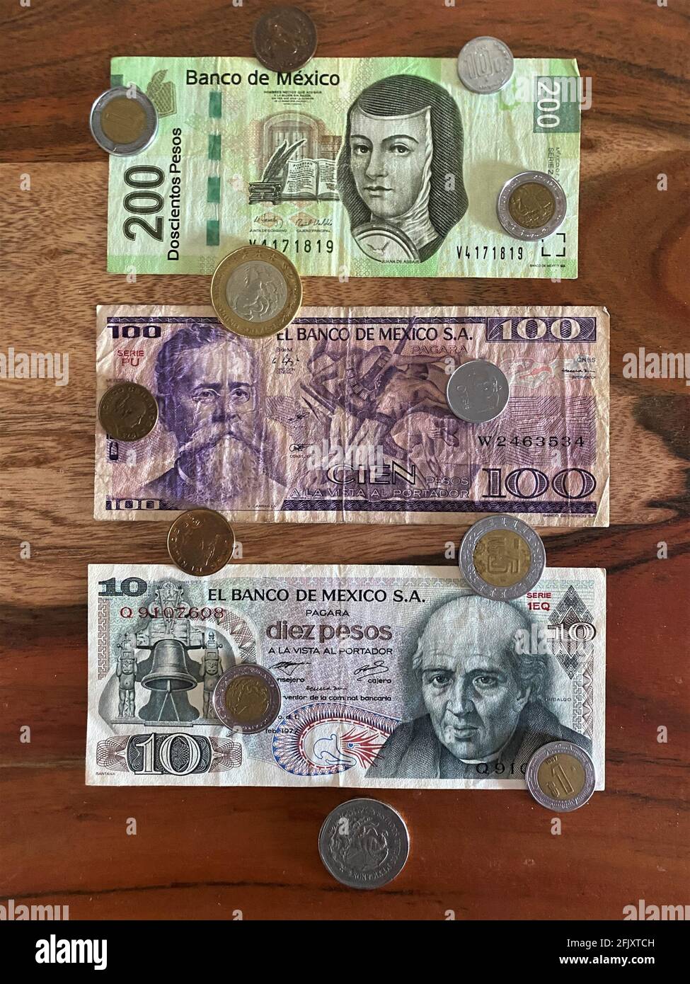 Pesos mexicains, billets de banque, billets de monnaie et pièces sur fond de bois. Monnaie mexicaine Banque D'Images