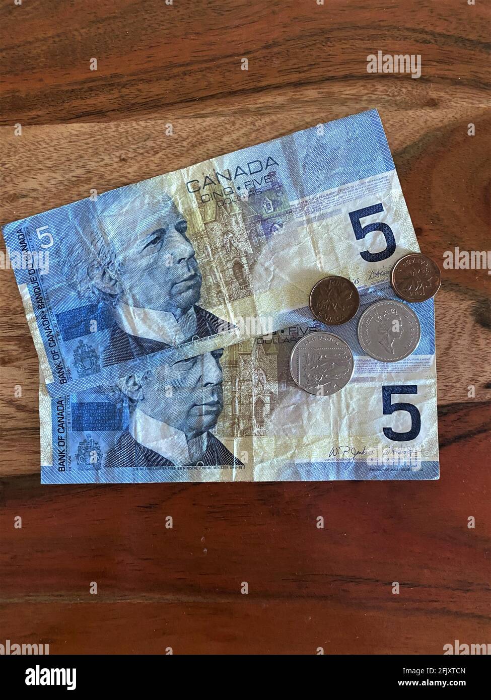 Billets, monnaie, banque et pièces de monnaie canadiens sur fond de bois Banque D'Images