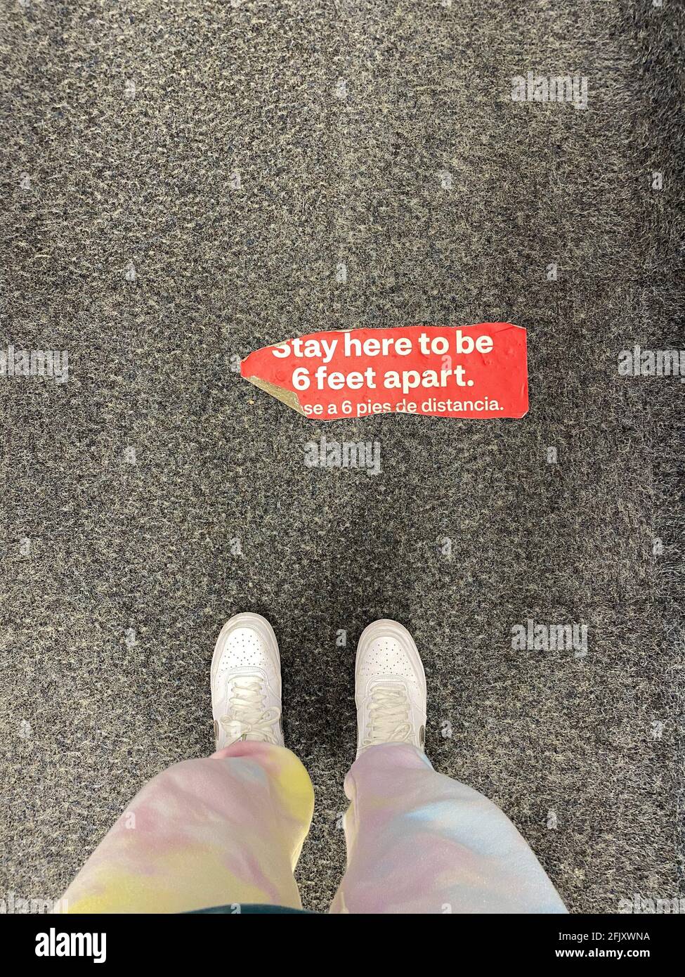 Affiche d'étage bilingue de la pharmacie CVS déchirée et estompée tapis de sol indiquant de rester à 6 pieds l'un de l'autre dans la ligne respecter les règles de distanciation sociale Banque D'Images