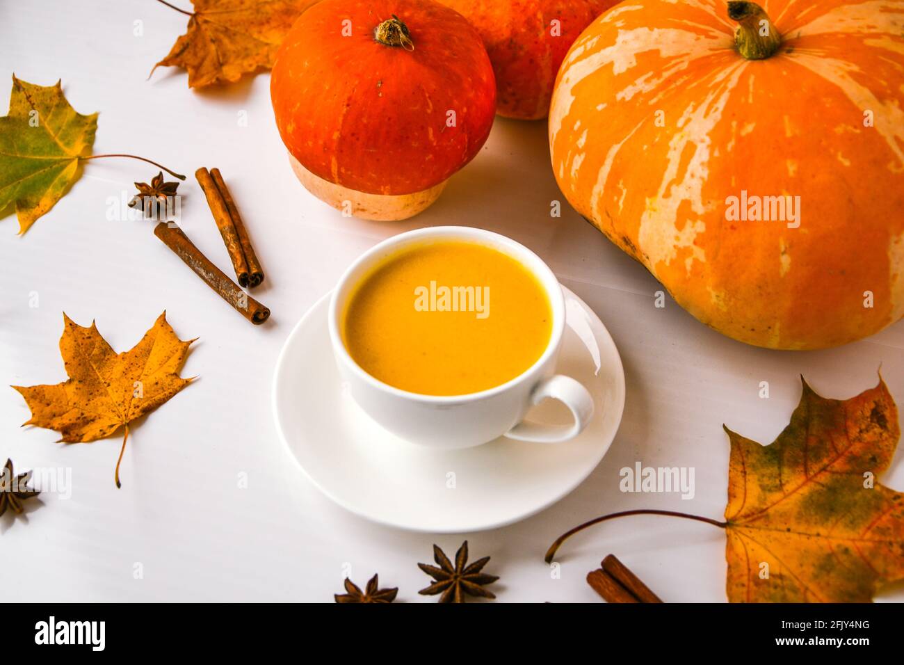 Smoothie à la citrouille, latte aux épices. Cocktail de butin avec bâtons de cannelle étoiles anis. Décorations feuilles d'érable. Boissons chaudes de saison en automne. Jour de Thanksgiving Banque D'Images