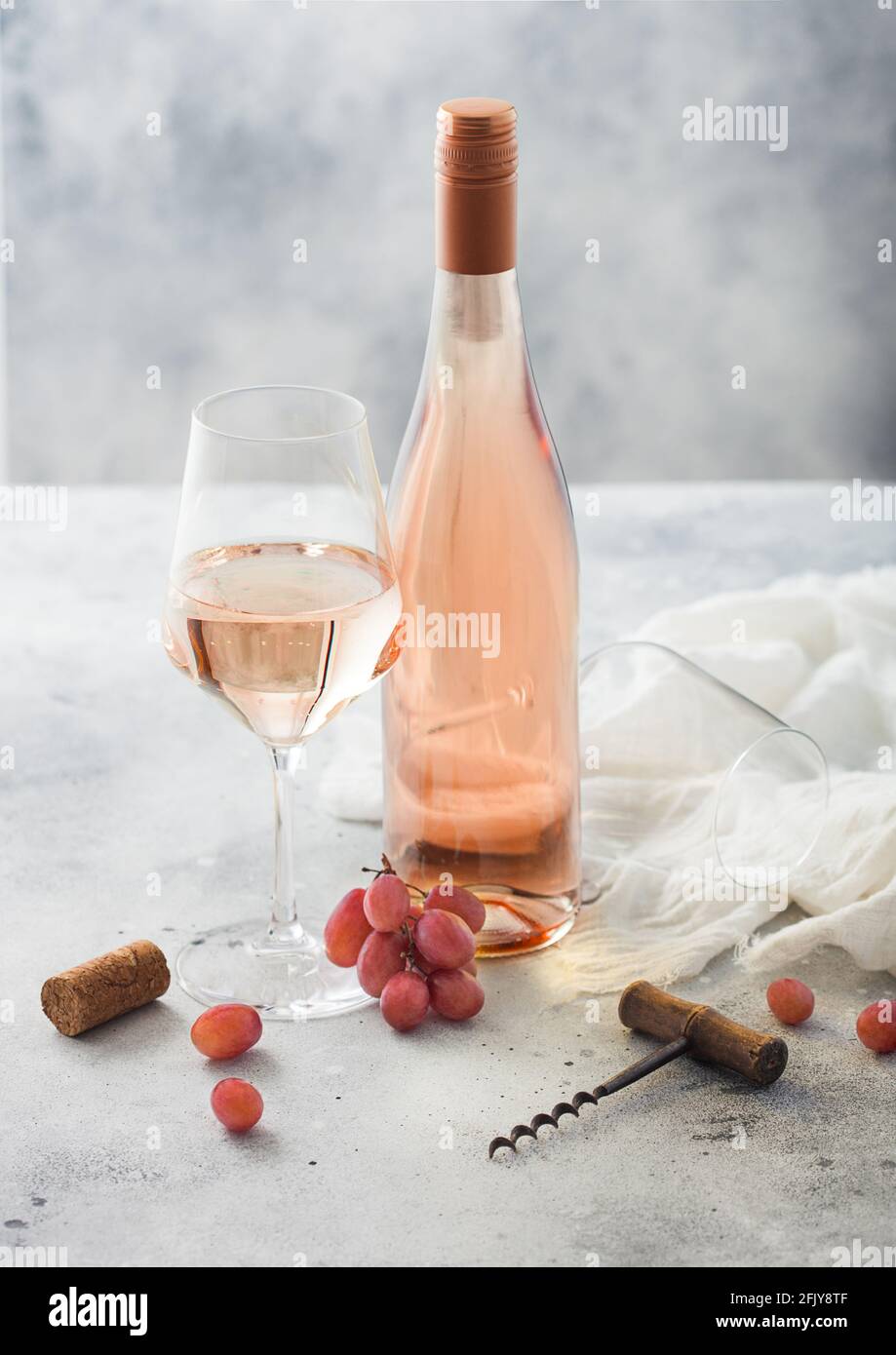 Bouteille et verre de vin rose maison avec bouchons, tire-bouchon et  raisins sur fond de table clair. Vue de dessus Photo Stock - Alamy